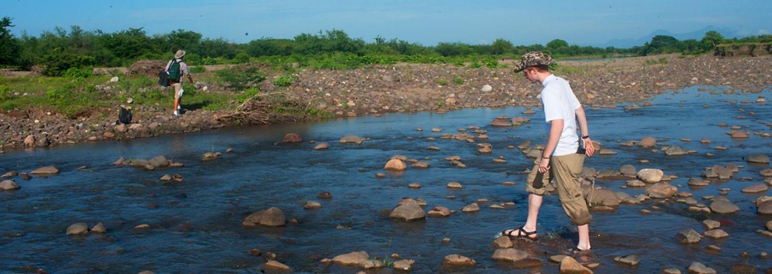 Student walking across stream 